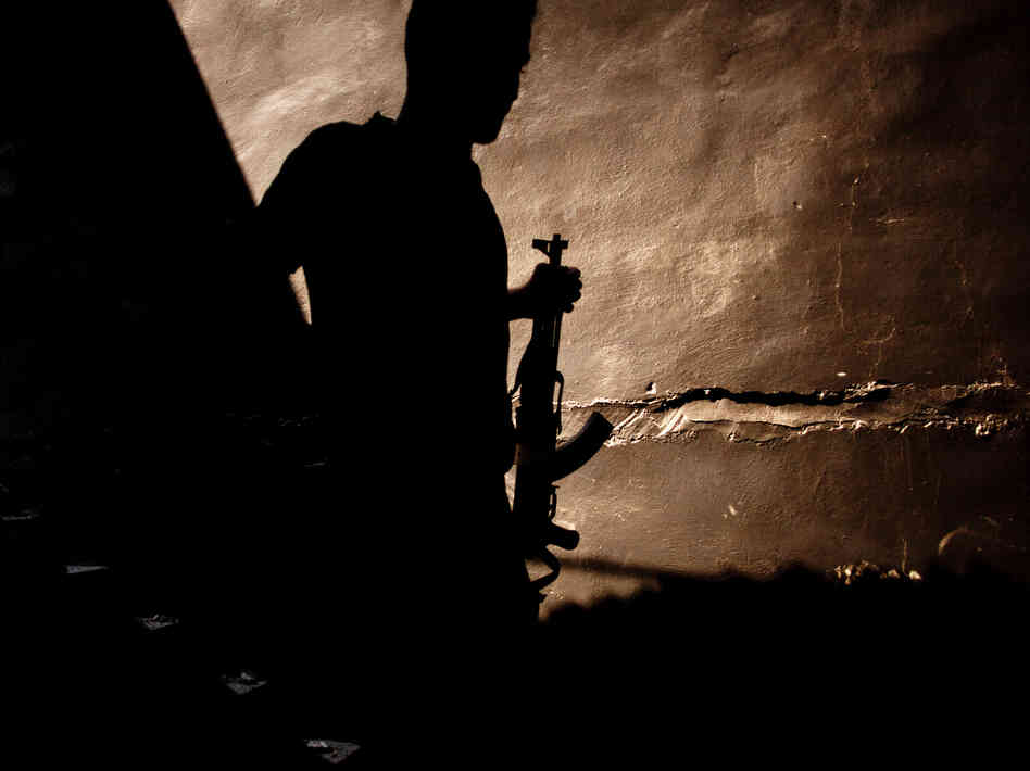 A Syrian rebel walks past the stairs of a bombed building in the Saif Al Duli district in Aleppo, Syria, on Sept. 10. The vast majority of those fighting against President Bashar Assad's regime are ordinary Syrians and soldiers who have defected, but Islamist rebels are also present among the fighters.