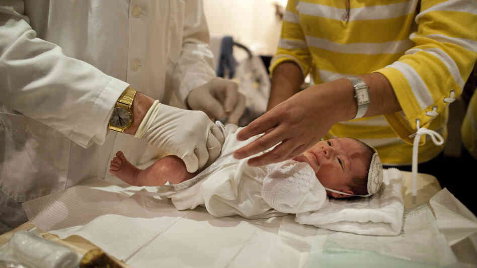 Rabbi A. Romi Cohn, a noted mohel, prepares an infant for circumcision at Congregation Shaare Zion in Brooklyn on Sept. 4. Cohn opposes a New York City rule requiring parental consent for a type of circumcision ritual practiced by some Orthodox Jews.