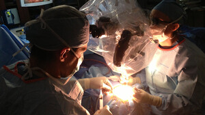 Neurosurgeons Ed Smith (left) and Sarah Jernigan operate on Maribel Ramos' brain. The monitor at upper left shows a portion of Maribel's brain, crossed by the healthy blood vessel they'll use to bring a new supply of blood to her oxygen-starved brain.