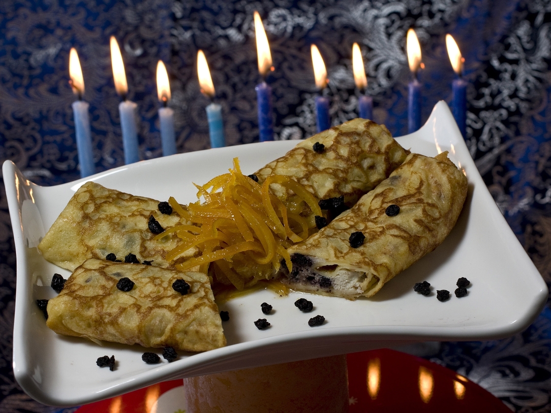 Lemon and dried blueberry blintzes, filled with creamy ricotta cheese, provide a tasty way to serve dairy and honor Judith for Hanukkah.