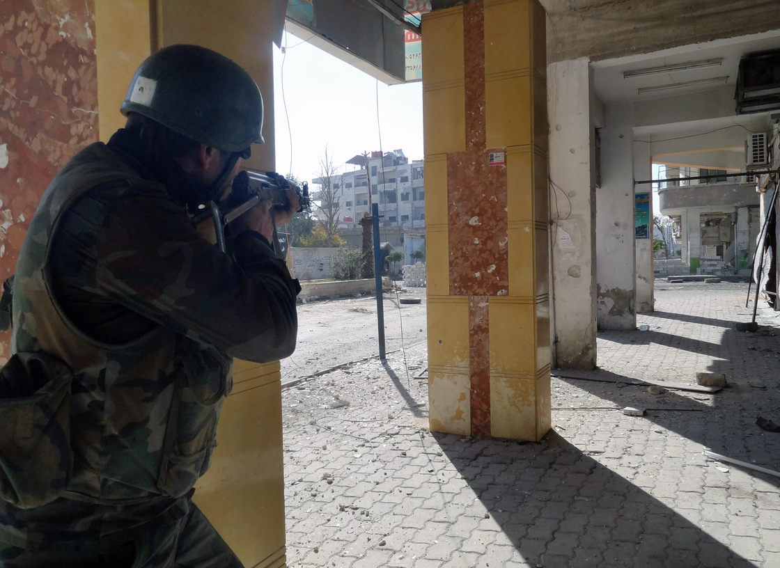 A Syrian soldier aims his rifle during clashes in the Damascus suburb of Daraya on Sunday. There is frequent fighting in and around Damascus, and residents are increasingly worried about a major battle for the capital.