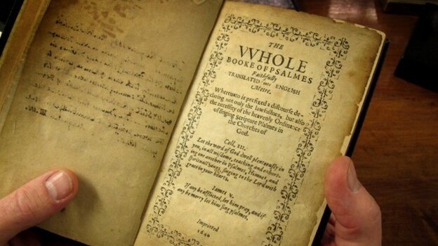 Jeff Makholm holds the Bay Psalm Book. (WBUR)