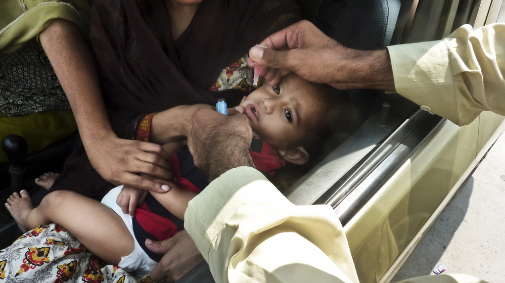 A child is inoculated with the polio vaccine at a traffic checkpoint just outside Pakistan's capital, Islamabad. Roadside vaccinations help health workers reach children in mobile populations.