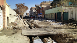 One of the streets undergoing renovation in Kabul. Residents often have to build makeshift bridges at their own expense to span the sewage trenches and reach their garages or driveways.