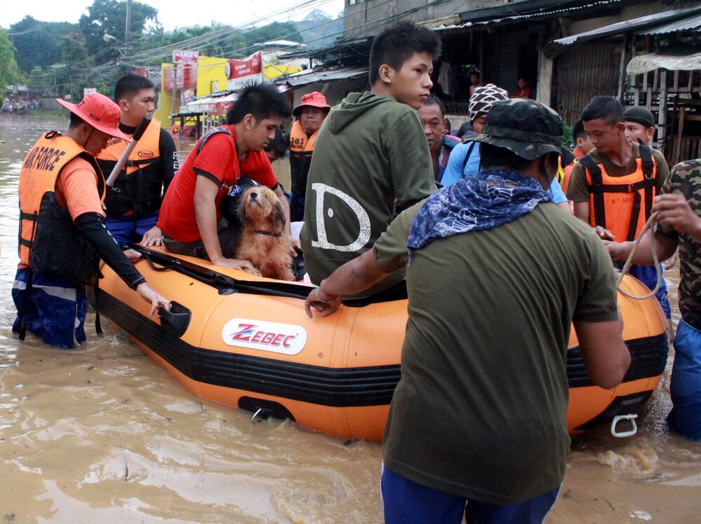 Philippine Air Force troops use a rubber boat to evacuate residents from floods in Cagayan de Oro City, southern Philippines earlier today (Dec. 4).