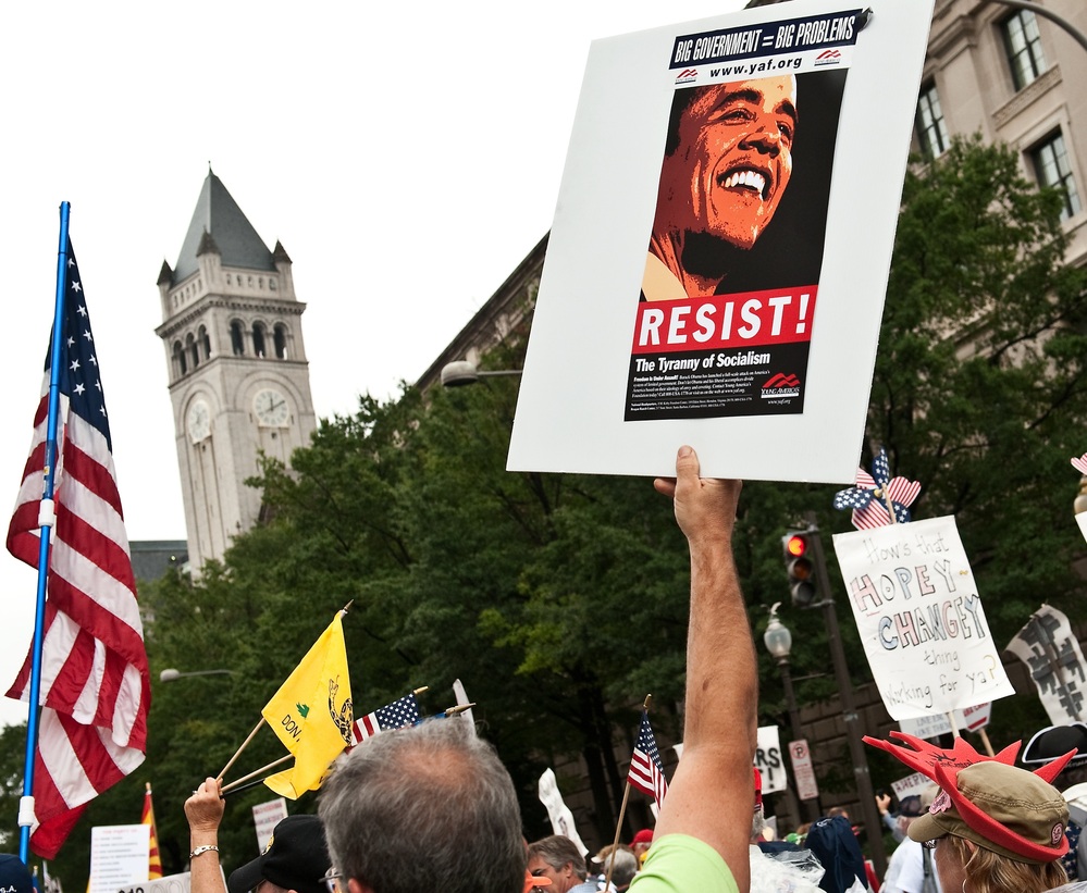A demonstrator carries a sign calling people to "resist" President Barack Obama perceived socialist policies during a march of supporters of the conservative Tea Party movement in Washington.