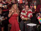 A screenshot of Jimmy Fallon and Mariah Carey performing "All I Want For Christmas Is You" with The Roots.