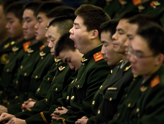 Must ... stay .... awake: A Chinese paramilitary police officer yawns and his colleagues fall asleep while then-President Hu Jintao delivers a speech at the Great Hall of the People in Beijing, China, Dec. 18, 2008.