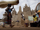 A woman walks by the Grand Mosque of Djenne on market day in Djenne, Mali, on Sept. 2. The UNESCO World Heritage-listed town is among the Malian tourist sites suffering from a huge drop in visitors after a coup took place in March and Islamist rebels seized control of the country's north. A woman walks by the Grand Mosque of Djenne on market day in Djenne, Mali, on Sept. 2. The UNESCO World Heritage-listed town is among the Malian tourist sites suffering from a huge drop in visitors after a coup took place in March and Islamist rebels seized control of the country's north.