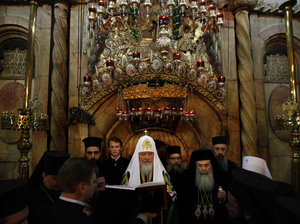 Greek Orthodox Patriarch of Jerusalem Theophilos III, right, and Russian Orthodox Patriarch Kirill, center, pray in front of the tomb of Jesus in the Church of the Holy Sepulcher on Nov. 9. The dispute over the church's water bill came to an end only after a meeting between Kirill and Israeli President Shimon Peres.