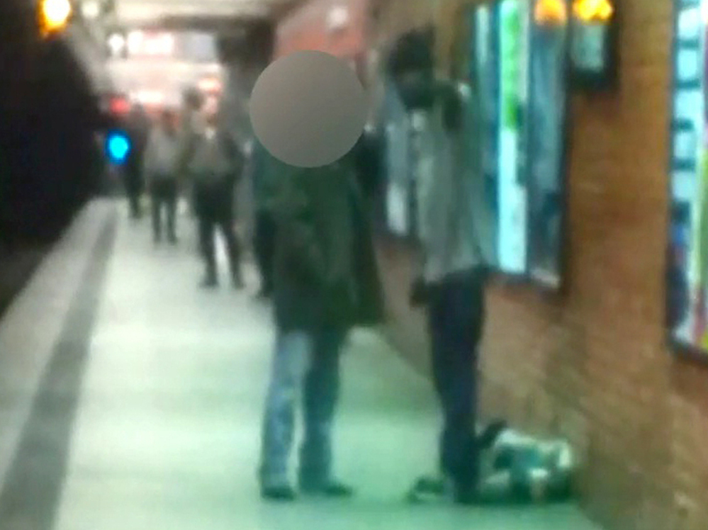 Before the attack: Two men are seen talking on a New York City subway platform Monday in this framegrab from a video released by the New York City Police Department. Moments later, police say, Ki-Suk Han (whose face is obscured) was pushed on to the tracks.
