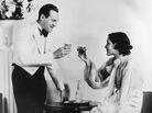A happy-looking 1930s couple toasts. A happy-looking 1930s couple toasts.