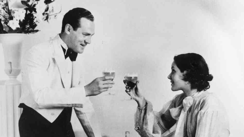 A happy-looking 1930s couple toasts. A happy-looking 1930s couple toasts.