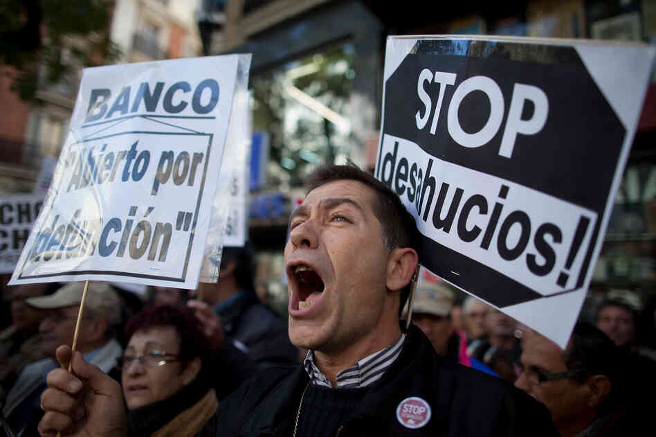 A demonstrator shouts during a protest against housing evictions in Madrid last month. The sign to his right reads, "Stop evictions." A demonstrator shouts during a protest against housing evictions in Madrid last month. The sign to his right reads, "Stop evictions."