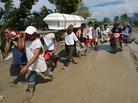 Residents carry a relative's coffin along a muddy road in the town of New Bataan, compostela province on Thursday. Nearly 200,000 people are homeless and more than 300 dead after the Philippines suffered its worst typhoon this year. Residents carry a relative's coffin along a muddy road in the town of New Bataan, compostela province on Thursday. Nearly 200,000 people are homeless and more than 300 dead after the Philippines suffered its worst typhoon this year.