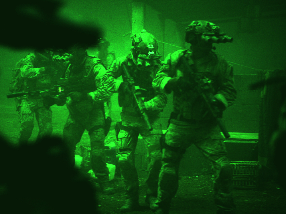 Seen through the greenish glow of night-vision goggles, Navy SEALs prepare to breach a locked door in Osama bin Laden's compound in Zero Dark Thirty.
