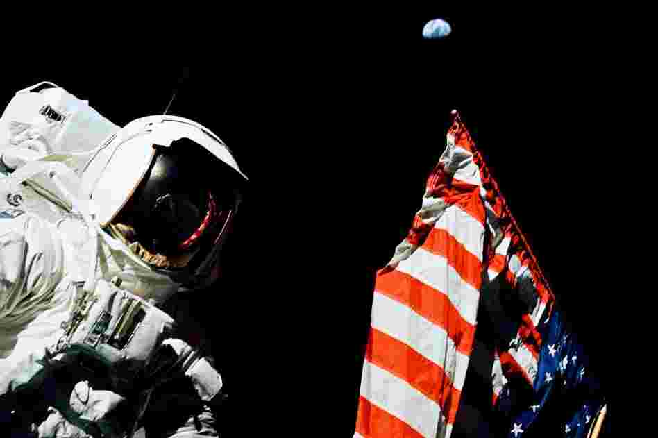 Schmitt stands by the American flag during a moonwalk. Look above the flag — that's Earth, a quarter-million miles away.