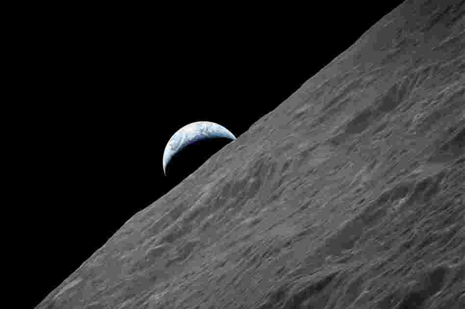 A camera aboard the Apollo 17 spacecraft captured this glimpse of Earth peeking out above the lunar horizon during the final lunar mission.