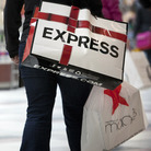 Shoppers carry bags during Black Friday sales at the South Shore Plaza in Braintree, Mass. Right now, consumers are feeling positive, but the mood among businesses is at recession levels.