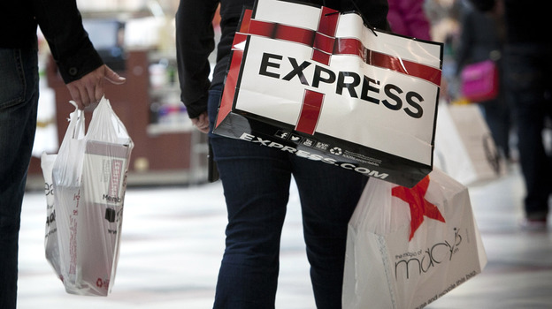 Shoppers carry bags during Black Friday sales at the South Shore Plaza in Braintree, Mass. Right now, consumers are feeling positive, but the mood among businesses is at recession levels.