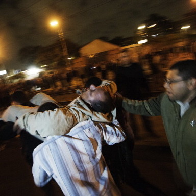 A man who had been with members of the Muslim Brotherhood and supporters of Egyptian President Mohamed Morsi when he was injured during overnight clashes in Cairo is carried from the scene by others.
