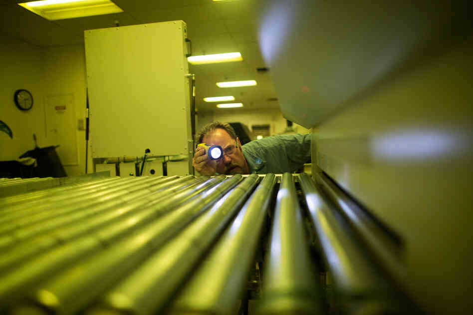 Bradley McComb, a production and maintenance mechanic, inspects a machine that makes metal plates for the presses.