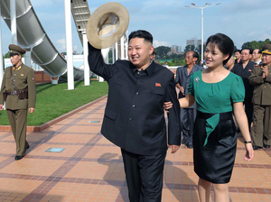 North Korean leader Kim Jong Un, center, accompanied by his wife Ri Sol Ju, waves to the crowd as they inspect the Rungna People's Pleasure Ground in Pyongyang on July 25 in this photo released by the Korean Central News Agency. For North Koreans, it was stunning to see the first lady at the leader's side — and holding his arm.