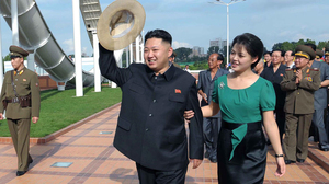 North Korean leader Kim Jong Un (center), accompanied by his wife, Ri Sol Ju, waves to the crowd as they inspect the Rungna People's Pleasure Ground in Pyongyang on July 25 in this photo released by the Korean Central News Agency. For North Koreans, it was stunning to see the first lady at the leader's side — and holding his arm.