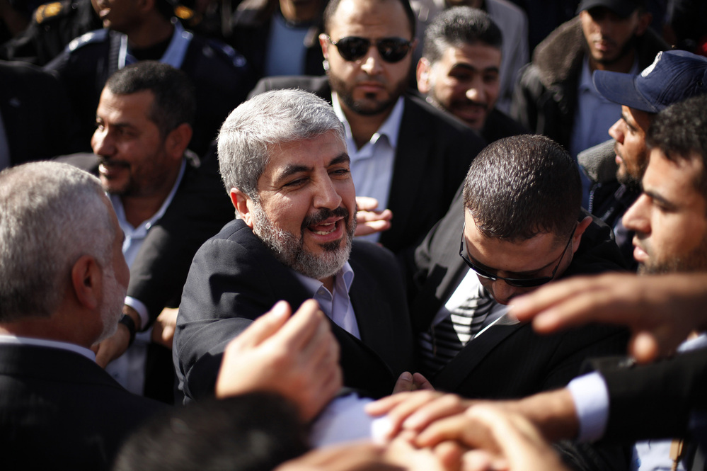 The exiled Hamas chief Khaled Mashaal shakes hands with supporters upon his arrival at Rafah crossing in the southern Gaza Strip.