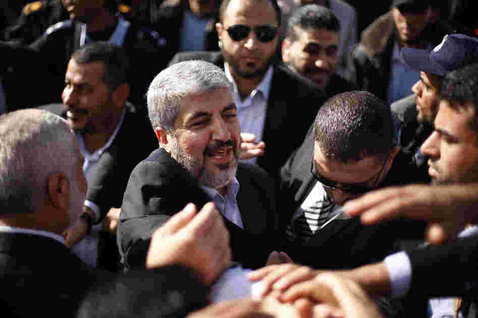 The exiled Hamas chief Khaled Mashaal shakes hands with supporters upon his arrival at Rafah crossing in the southern Gaza Strip.