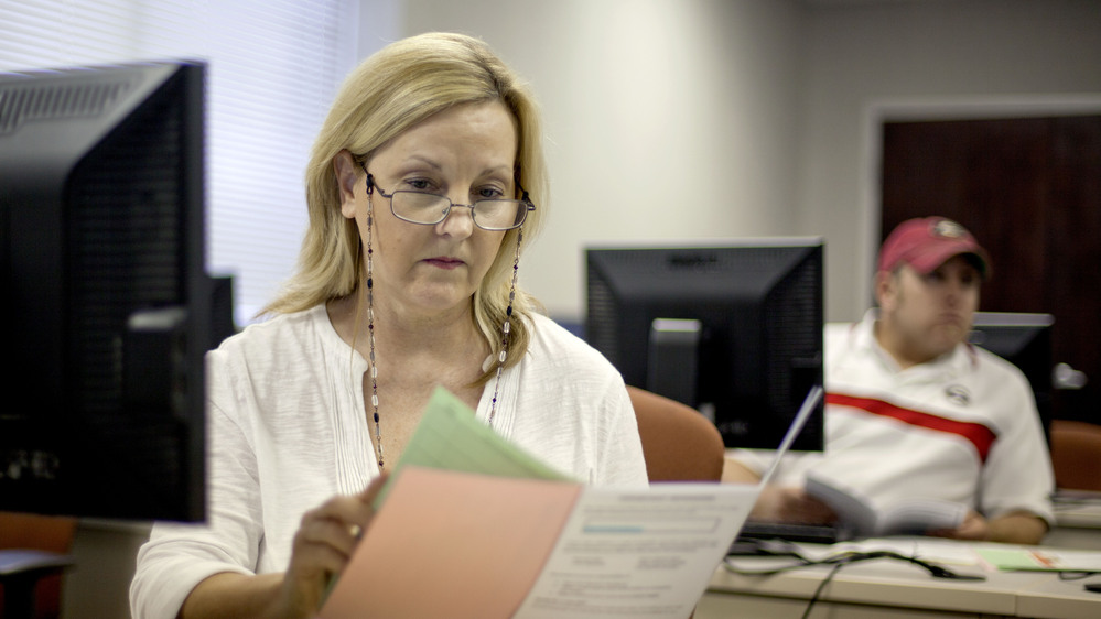 Judy Smith, of Dalton, Ga., looks over paperwork as she files for unemployment benefits in August after being laid off from a catering job. More than 2 million people who get extended benefits may lose them if Congress doesn't act soon.