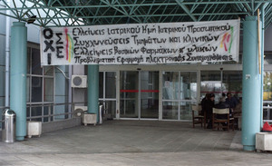 A hand-painted banner decrying drastic cuts to the health care budget is draped on the main entrance of the Regional Hospital of Serres in northern Greece.