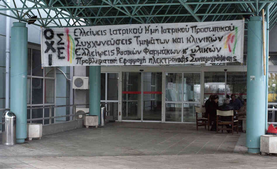 A hand-painted banner decrying drastic cuts to the health care budget is draped on the main entrance of the Regional Hospital of Serres in northern Greece.
