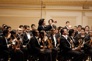 Gustavo Dudamel wades through the orchestra just before the start of the Carnegie Hall concert.