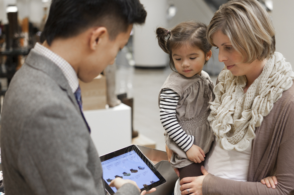A Nordstrom salesperson shows a customer an online selection of shoes on an in-store iPad. Like some other retailers, Nordstrom is using mobile devices to make on-the-spot sales and check companywide product inventory instantly.