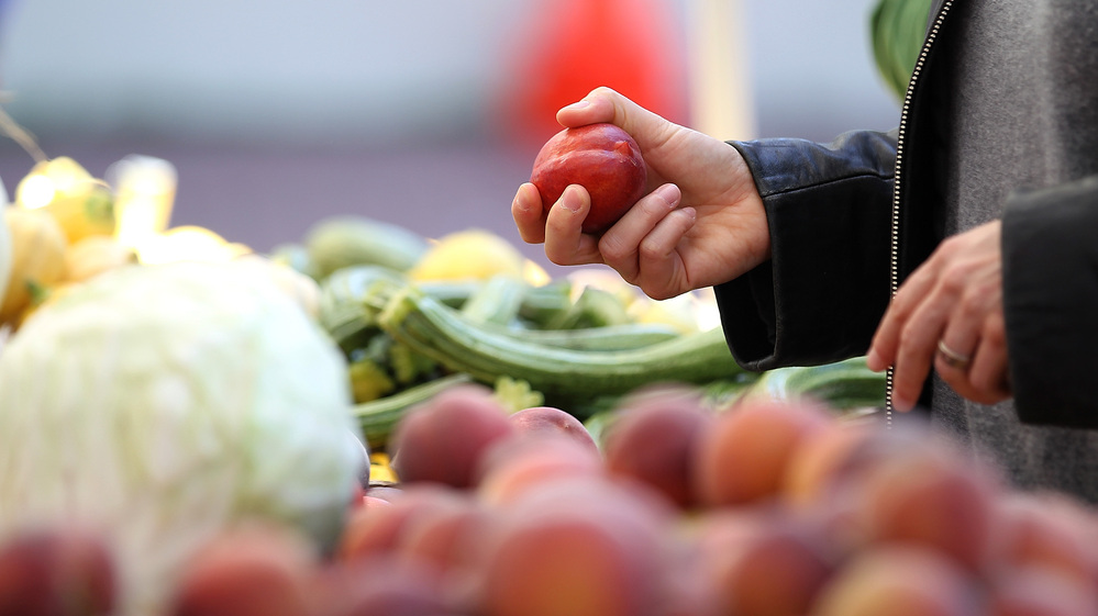A customer shops for nectarines at a farmers market in San Francisco. A customer shops for nectarines at a farmers market in San Francisco.
