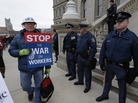 A right-to-work protester walks past Michigan state police at the capitol in Lansing on Tuesday. The Michigan Legislature is expected to pass legislation Tuesday that would bar contracts requiring employees to pay union dues as a condition of employment. A right-to-work protester walks past Michigan state police at the capitol in Lansing on Tuesday. The Michigan Legislature is expected to pass legislation Tuesday that would bar contracts requiring employees to pay union dues as a condition of employment.
