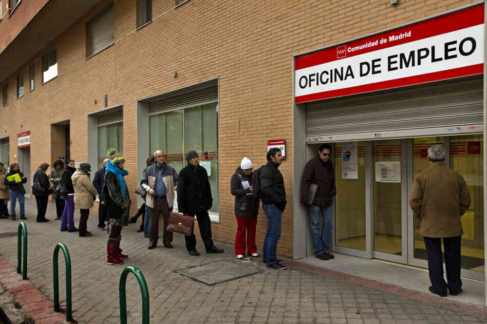 People queue up at a government job center in Madrid this month. The unemployment rate in Spain now tops 25 percent, but many government workers still enjoy job security and higher wages than their private sector counterparts. People queue up at a government job center in Madrid this month. The unemployment rate in Spain now tops 25 percent, but many government workers still enjoy job security and higher wages than their private sector counterparts.