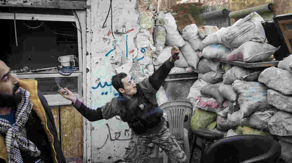 To date, Syrian rebels have had to rely on small-scale weapons in their fight against the Syrian army. Here, a rebel fighter throws an explosive device toward a Syrian government position in the northern city of Aleppo last month.