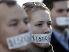 Silent protesters Wednesday in Lansing, Mich., wear tape with messages that signify wages they say they could lose because of the state's new right-to-work law. Silent protesters Wednesday in Lansing, Mich., wear tape with messages that signify wages they say they could lose because of the state's new right-to-work law.