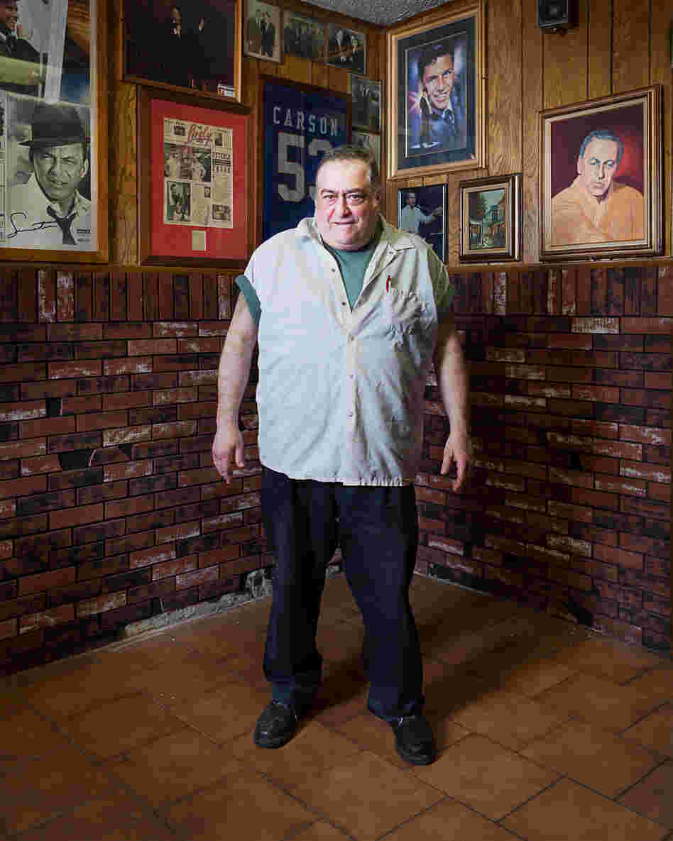 Patty, cook and owner at Piccolo's Clam Bar, standing in the "Sinatra room"