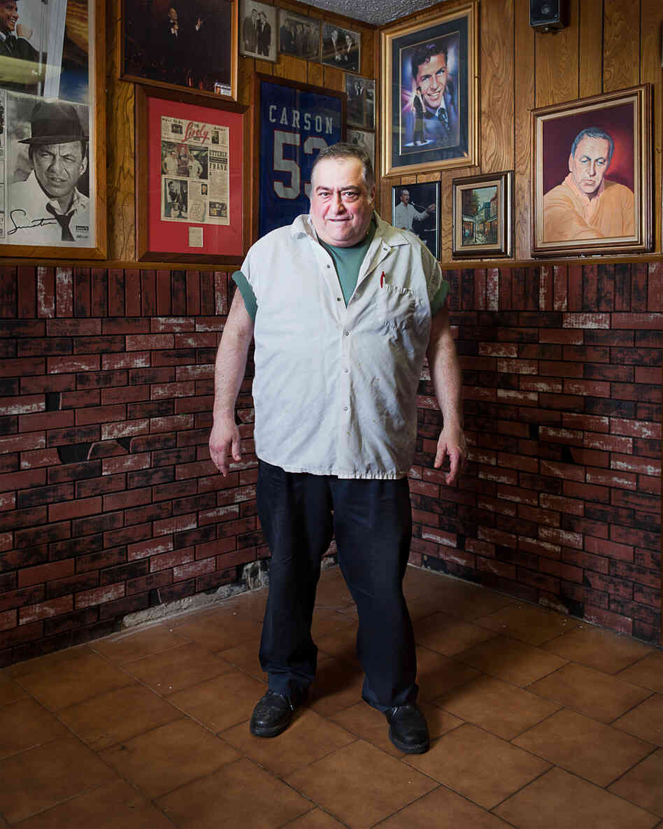 Patty, cook and owner at Piccolo's Clam Bar, standing in the "Sinatra room"