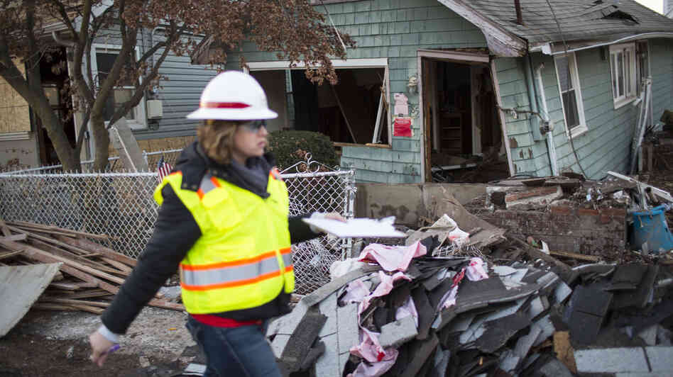 A woman with the Army Corps of Engineers documents a destroyed home last month in a residential area of New Dorp Beach on Staten Island in New York City. A woman with the Army Corps of Engineers documents a destroyed home last month in a residential area of New Dorp Beach on Staten Island in New York City.