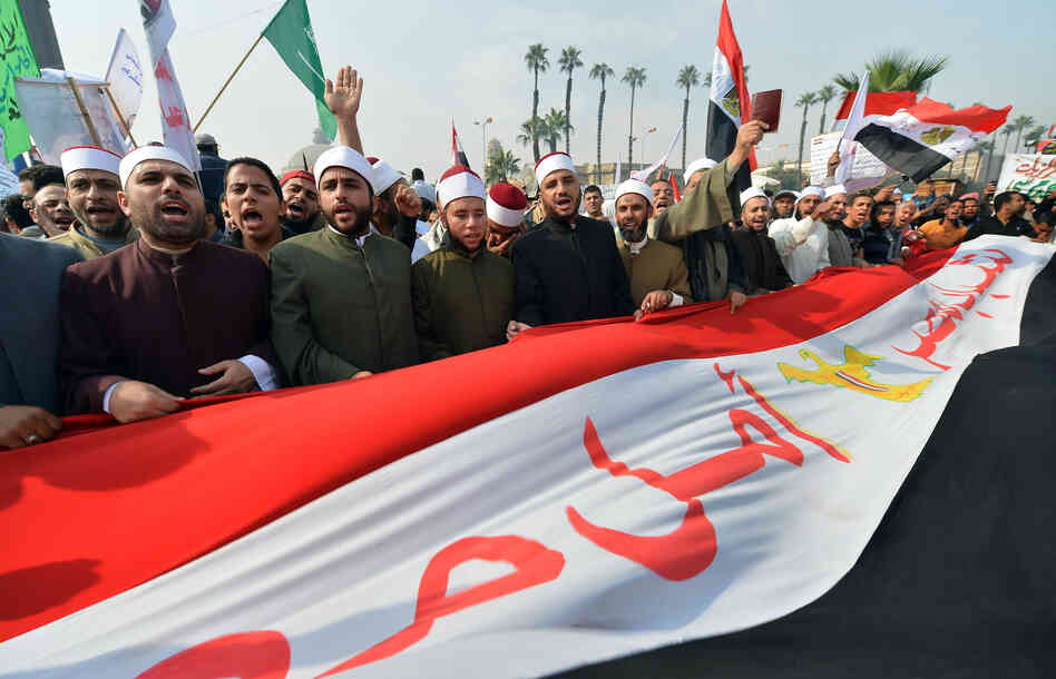 Egyptian clerics from Al-Azhar University hold a national flag as they shout support for President Mohammed Morsi and a new constitution at a rally in Cairo on Dec. 1. Secular and Islamist Egyptians disagree on the constitution, which critics say gives too much power to the clerics of Al-Azhar, the seat of Sunni Islam learning.