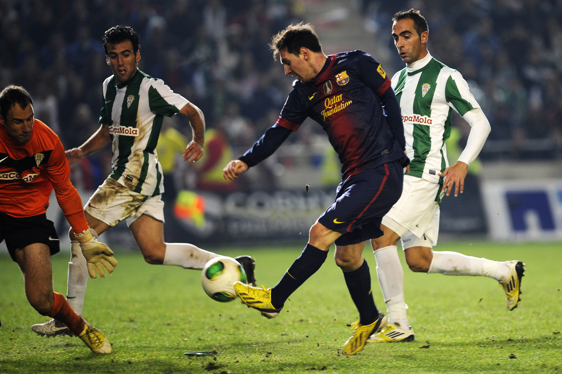 Barcelona forward Lionel Messi (in dark blue) shoots on Cordoba's goalkeeper Mikel Saizar (left) during the Spanish Copa del Rey football match in Cordoba on Wednesday.
