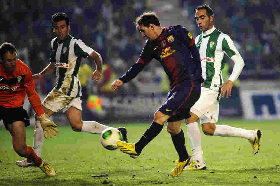 Barcelona forward Lionel Messi (in dark blue) shoots on Cordoba's goalkeeper Mikel Saizar (left) during the Spanish Copa del Rey football match in Cordoba on Wednesday.