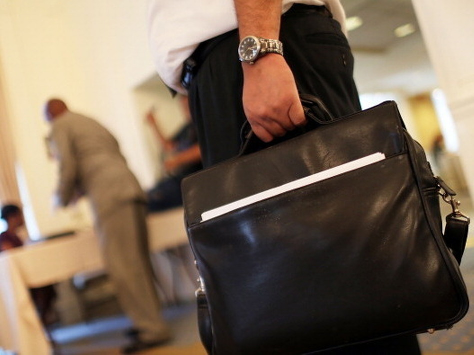 At a job fair in New York City earlier this year, a man waited for an interview. Economists say the job market is slowly improving, and the latest data on jobless claims seem to support that analysis.