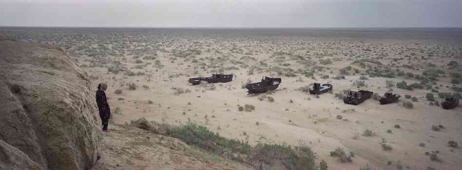 A local woman sees abandoned ships in what used to be the Aral Sea, May 2012. The Aral Sea has been shrinking since the 1960s because of irrigation projects.