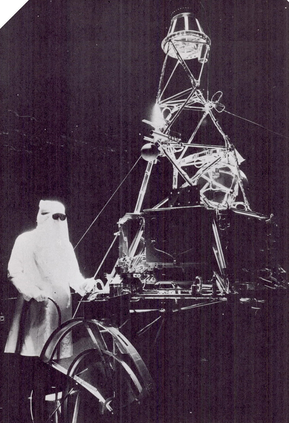 A technician wears a hood and protective goggles while working with a full-scale model of the Mariner spacecraft in a space simulator chamber at the Jet Propulsion Laboratory in Pasadena, Calif., in 1962.