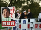 Supporters hold up posters of Japan's former Prime Minister Shinzo Abe at a rally in Osaka on Thursday. Considered a nationalist hawk, Abe is expected to become prime minister for a second time after parliamentary elections Sunday. Supporters hold up posters of Japan's former Prime Minister Shinzo Abe at a rally in Osaka on Thursday. Considered a nationalist hawk, Abe is expected to become prime minister for a second time after parliamentary elections Sunday.